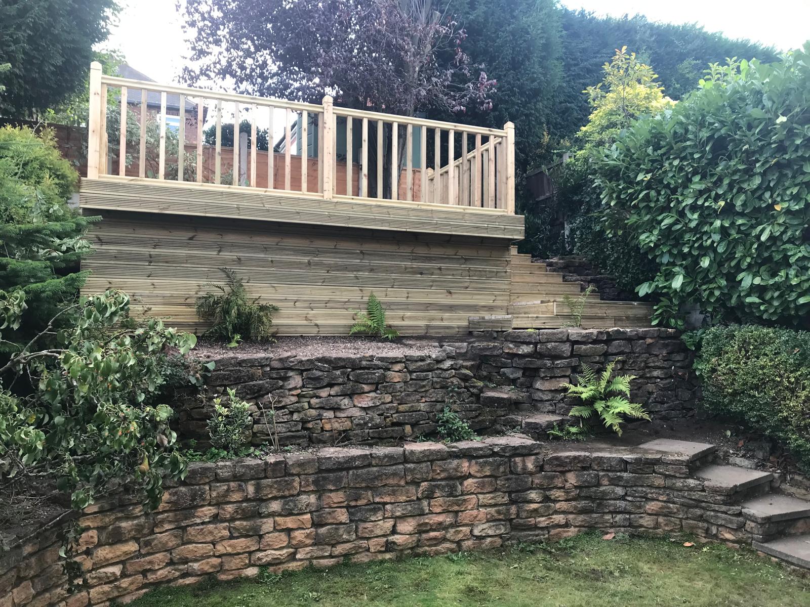 Completed raised deck with balustrade above stone terracing
