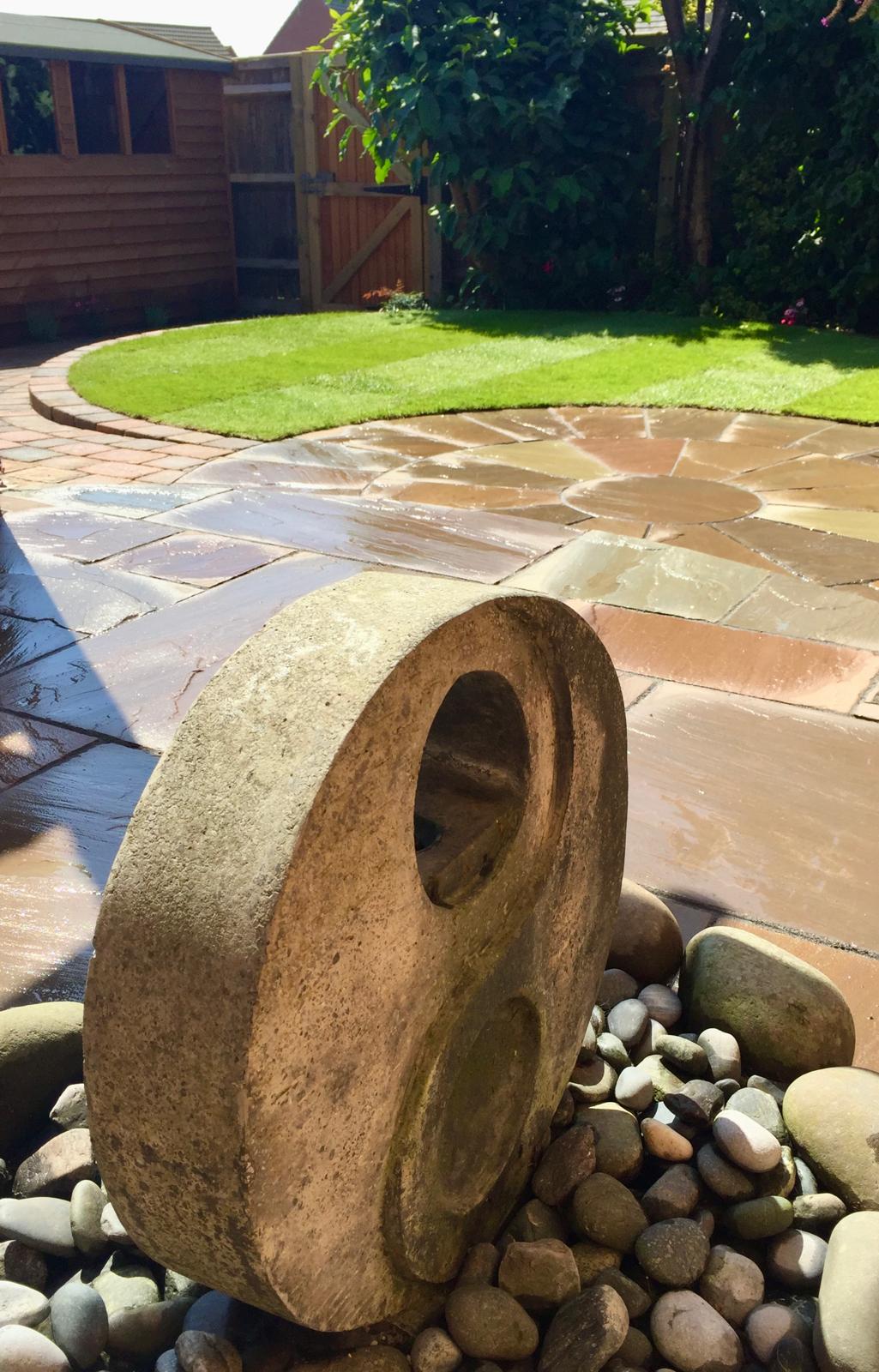 Circular paved garden with millstone feature