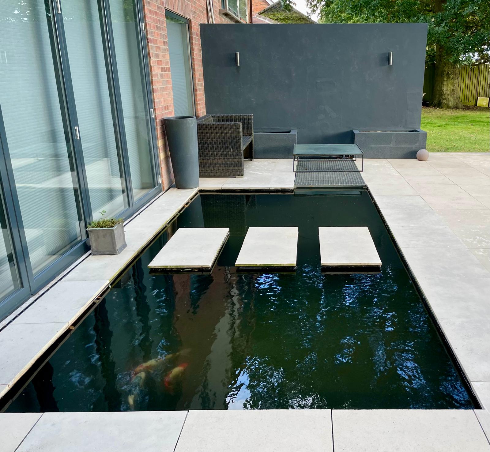 Koi pond with fish visible beneath stepping slabs