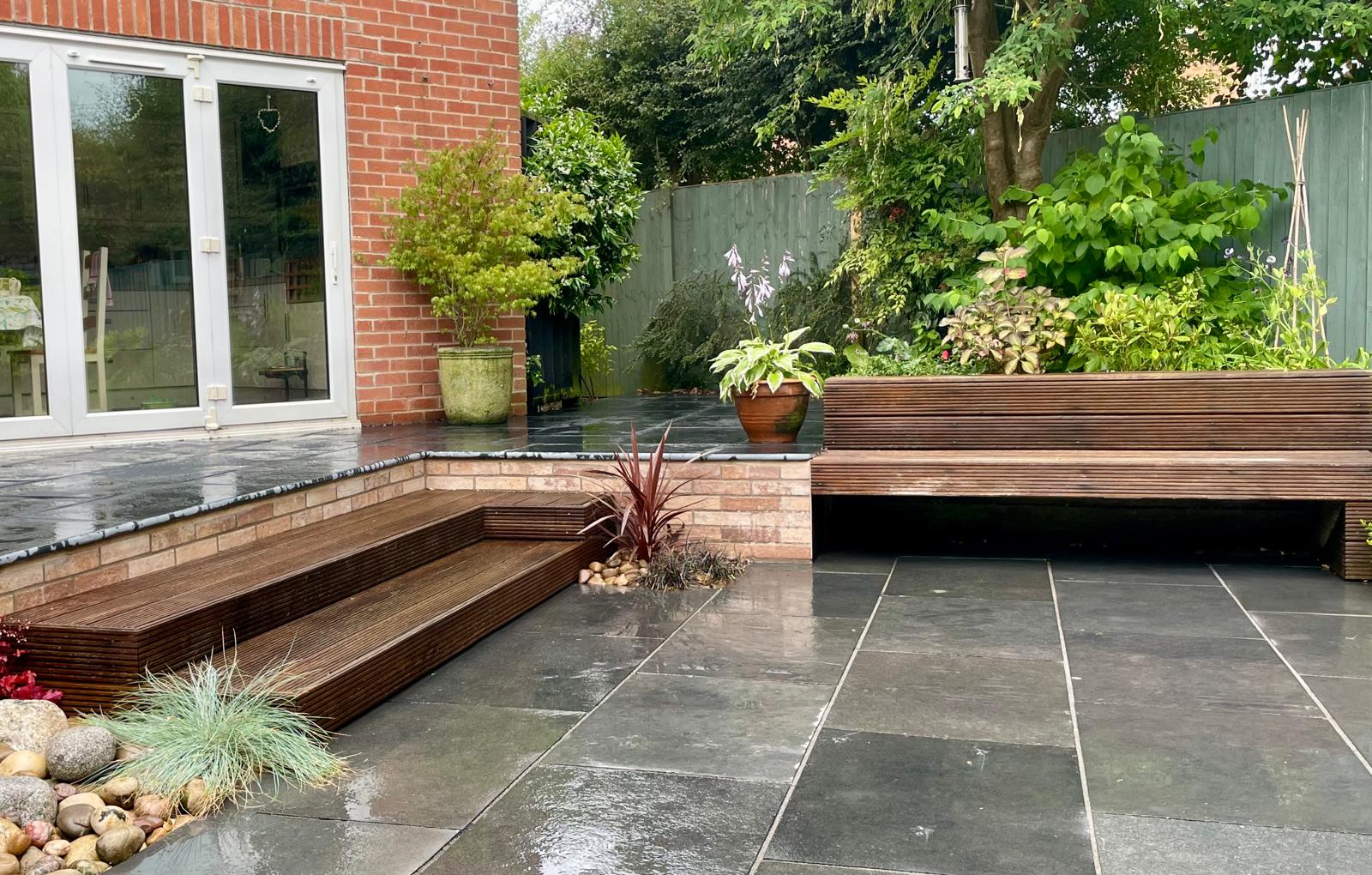 Slate patio with hardwood steps and raised beds