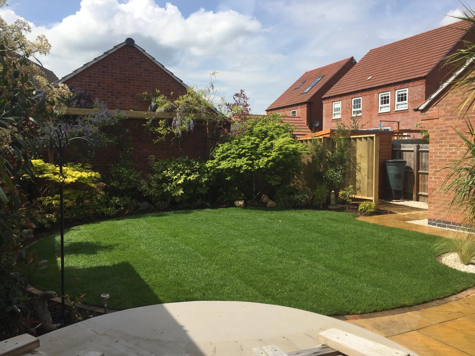 Suburban garden with artificial lawn and wisteria pergola