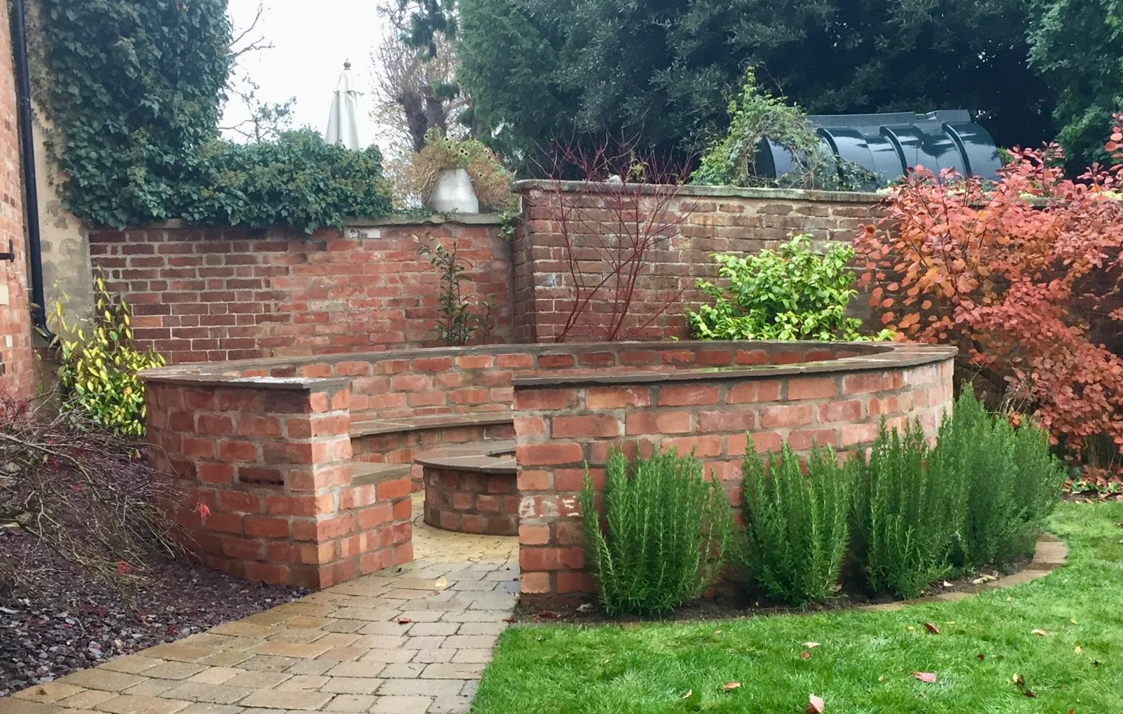 Brick wall with integrated bench seating and rosemary planting