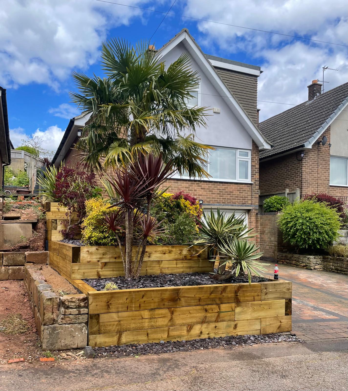 Timber sleeper raised beds with exotic planting — front view